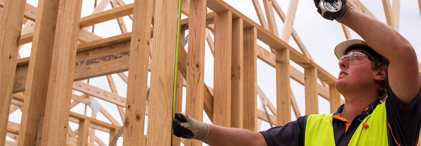 builder measuring timber frame