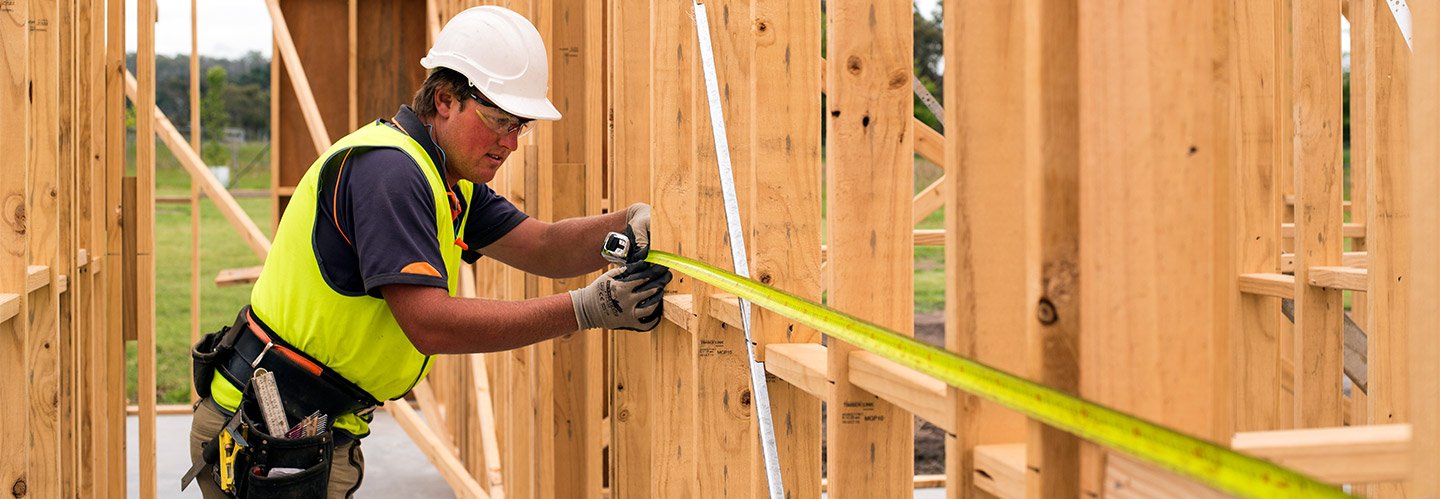 tradie measuring timber frame